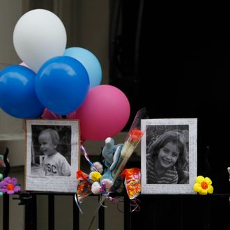 FILE - In this Oct. 27, 2012 file photo, Photographs of the two children allegedly stabbed by their nanny are displayed alongside balloons and stuffed animals at memorial outside the apartment building were they lived in New York. Yoselyn Ortega, the nanny, has pleaded not guilty in the stabbing deaths of the two children. Ortega was arraigned Wednesday, Nov. 28, 2012 at a hospital where she has been treated for self-inflicted stab wounds. Six-year-old Lucia Krim and her 2-year-old brother, Leo, were killed Oct. 25 in their Upper West Side apartment. Their mother found them when she came home with the victims' 3-year-old sister. (AP Photo/Mary Altaffer)