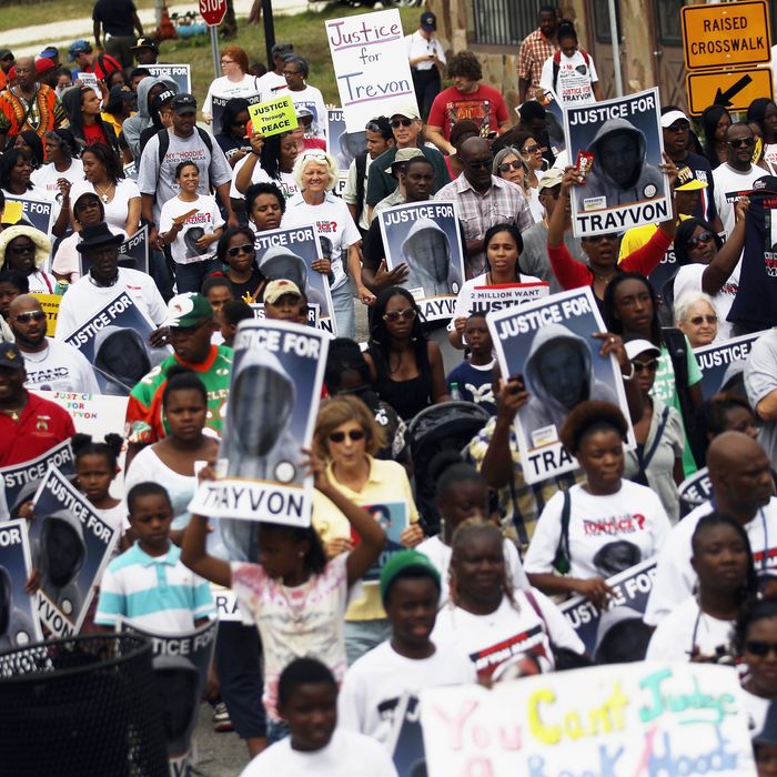 SANFORD, FL - MARCH 31: Trayvon Martin supporters march through the historically African American community of Goldsboro on their way to an NAACP rally in front of the Sanford Police Department on March 31, 2012 in Sanford, Florida. Martin was killed by George Michael Zimmerman while on neighborhood watch patrol in the gated community of The Retreat at Twin Lakes. Rev. Jesse Jackson, Rev. Al Sharpton and NAACP President Benjamin Jealous were amongst the supporters demanding Zimmerman's arrest. (Photo by Mario Tama/Getty Images)
