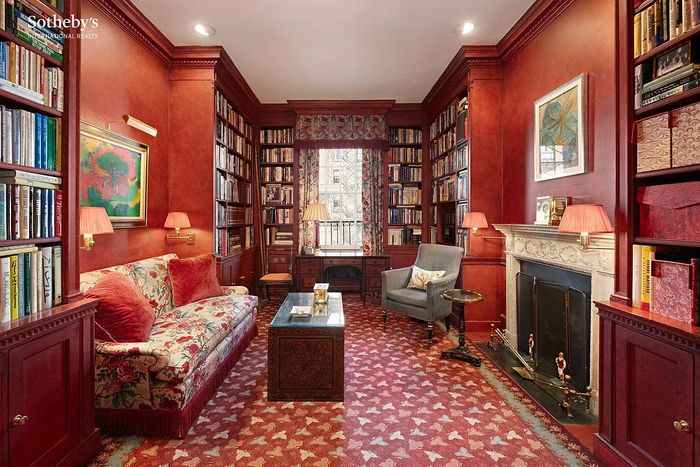 A tomato red library with custom cabinetry