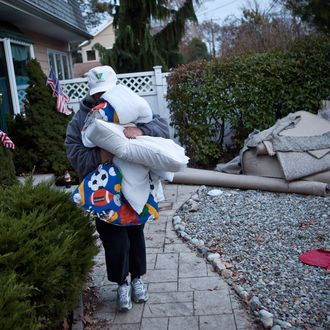 Trisha McAvoy carries bedding to her car while evacuating from her home due to an approaching storm on November 6, 2012 in Brick Township, New Jersey. As the New Jersey coastline continues to recover from Hurricane Sandy, numerous polling stations have had to be relocated and aggregated together, due to storm damage and power outages. 