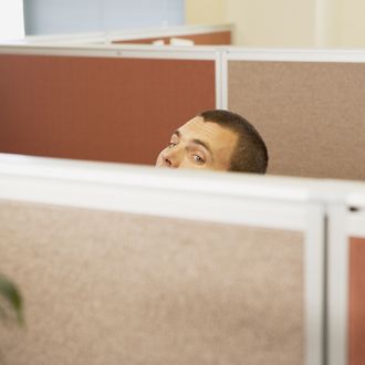 Man looking over partition in office