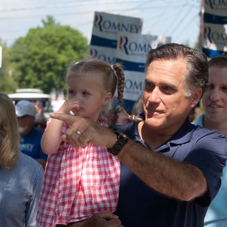 WOLFEBORO, NH - JULY 4: Republican presidential candidate, former Massachusetts Gov. Mitt Romney holds his granddaughter Soleil Romney, 3 as he walks in the Wolfeboro Independence Day parade on July 4, 2012 in Wolfeboro, New Hampshire. The Romney's took a break from their vacation to march in the parade. (Photo by Kayana Szymczak/Getty Images)