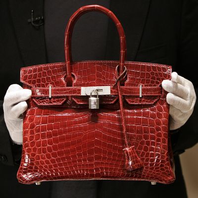 A employee holds a 129,000 USD crocodile