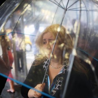  A woman walks through the rain under an umbrella on 5th Avenue in Midtown Manhattan on July 15, 2014 in New York City. 