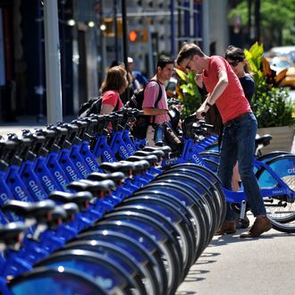 A couple get their Citi Bike bicycles from a station near Union Square as the bike sharing system is launched May 27, 2013 in New York. About 330 stations in Manhattan and Brooklyn will have thousands of bicycles for rent. 