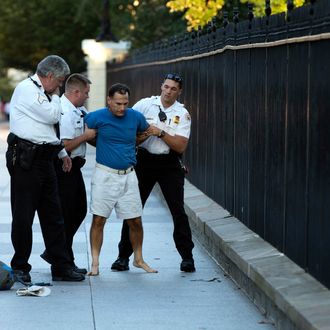 A man is taken into custody by uniformed Secret Service Police on Pennsylvania Avenue outside the White House on Monday, Sept. 16, 2013, in Washington. The Secret Service arrested the man for tossing lit firecrackers over the White House fence. (AP Photo/ Evan Vucci)