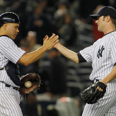 David Robertson #30 of the New York Yankees is congradulated by teammate Russell Martin #55 of the New York Yankees after defeating the Tampa Bay Rays at Yankee Stadium on May 8, 2012 in the Bronx borough of New York City. Yankees defeated the Rays 5-3.