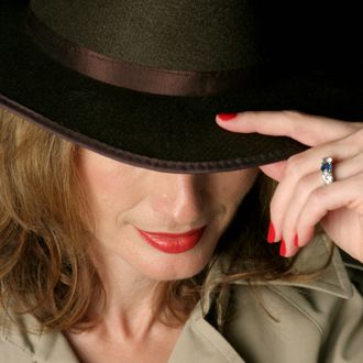 A beautiful, sexy woman in a trenchcoat and fedora hat.