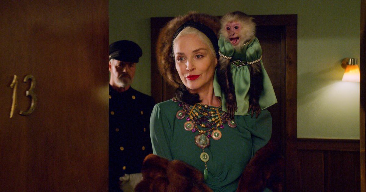 この写真では、シャロン・ストーンは肩にドレスを着た猿を持っています