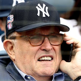 Rudy Giuliani wearing a Yankees cap and on the phone at Monday's Yankees game.
