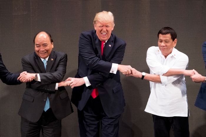 President Trump makes a weird face as he holds hands with other world leaders during the ASEAN Summit in Manila on November 13, 2017.