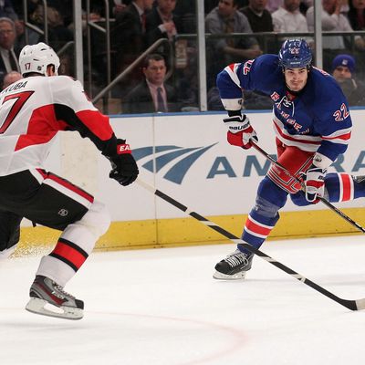 Brian Boyle #22 of the New York Rangers shoots the puck against Filip Kuba #17 of the Ottawa Senators at Madison Square Garden on January 12, 2012 in New York City. 