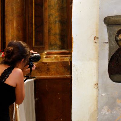 A woman takes pictures of the deteriorated version of 