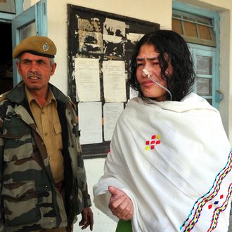 TO GO WITH India-unrest-Manipur-politics,FEATURE by Abhaya Srivastava A policewoman escorts civil rights activist, Irom Sharmila Chanu (R) also known as the 