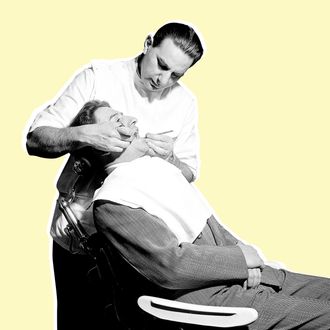 Original caption: Photo shows a dentist working on a patient in the dentist's office. Models: C.H. Cohen, D.D.S. and Emil Romano, the patient. Ca. 1940s-1950s. --- Image by ? Bettmann/CORBIS