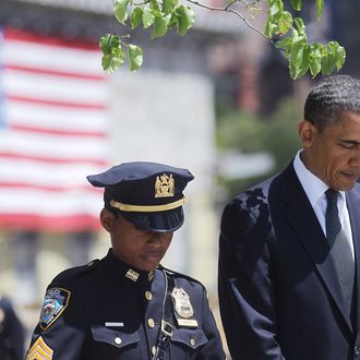 President Barack Obama (R) and New York Police Department officer Stephanie Moses bow their heads at a wreath laying ceremony at Ground Zero, after Osama bin Laden was killed on May 5, 2011 in New York City. Obama also visited a New York Fire Department firehouse and met with families of victims of the terrorist attack on September 11, 2001during his visit to New York. 