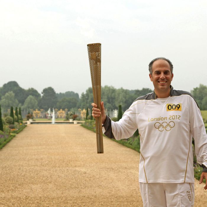 In this handout image provided by LOCOG, Torchbearer 009 Mark Levy holds the Flame in the grounds of Hampton Court Palace during the final day on July 27, 2012 in London, England.