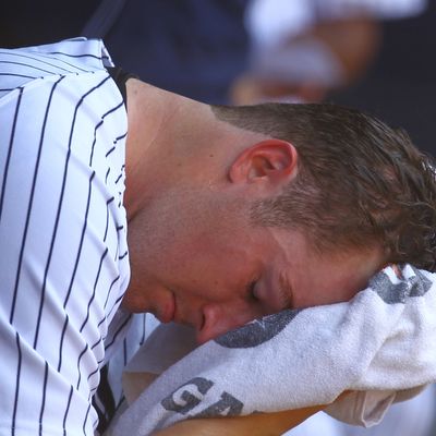 Phil Hughes #65 of the New York Yankees sits in the dugout after being removed from the game in the fifth inning against the Atlanta Braves during their game on June 20, 2012 at Yankee Stadium in the Bronx borough of New York City.