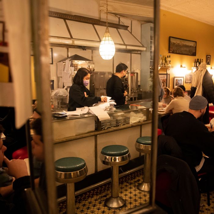 People dining inside a warmly lit restaurant in Manhattan's Chinatown