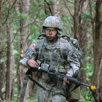 In a May 9, 2012 photo, Capt. Sara Rodriguez of the 101st Airborne Division walks through the woods during the expert field medical badge testing at Fort Campbell, Ky., on May 9, 2012. Female soldiers are moving into new jobs in once all-male units as the U.S. Army breaks down formal barriers in recognition of what's already happened in wars in Iraq and Afghanistan. (AP Photo/Kristin M. Hall)