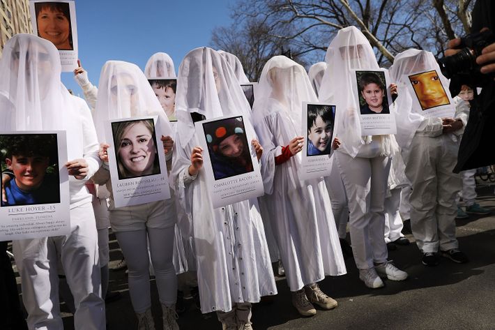 Students in New York City holding photos of students who have lost their lives to gun violence.