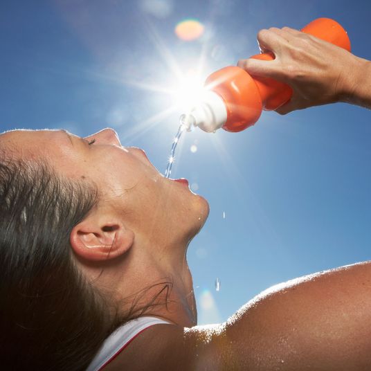 Female athlete drinking water.