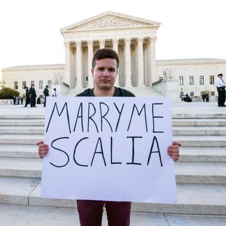 RYAN AQUILINA holds a sign as pro and anti-gay marriage demonstrators rally outside the U.S. Supreme Court on the morning that oral arguments on the question of same sex marriage are heard.