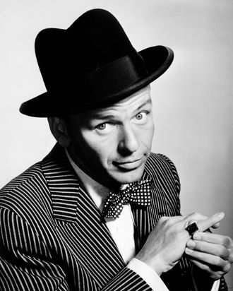 Pop singer Frank Sinatra poses for a portrait sporting a hat and bow tie and showing off a ring on his pinky in circa 1950.