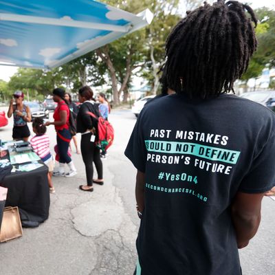 People gather around the Ben & Jerry’s “Yes on 4” truck as they learn about Amendment 4 and eat free ice cream at Charles Hadley Park in Miami on October 22, 2018.