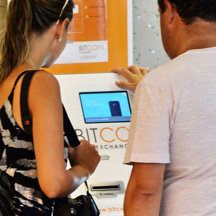 A couple checks a Bitcoin dispensing machine at a shopping mall in Singapore on March 6, 2014. Singapore's police said March 6 they were investigating the 