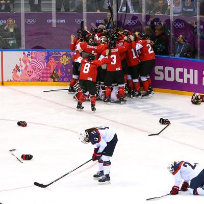 Marie-Philip Poulin #29 of Canada celebrates with teammates after scoring the game-winning goal against the United States in overtime as Anne Schleper #15 and Michelle Picard #23 of the United States react during the Ice Hockey Women's Gold Medal Game on day 13 of the Sochi 2014 Winter Olympics at Bolshoy Ice Dome on February 20, 2014 in Sochi, Russia. 