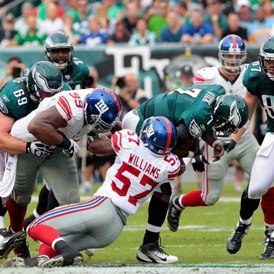 Michael Vick #7 of the Philadelphia Eagles is sacked by Jacquian Williams #57 of the New York Giants at Lincoln Financial Field on September 25, 2011 in Philadelphia, Pennsylvania.