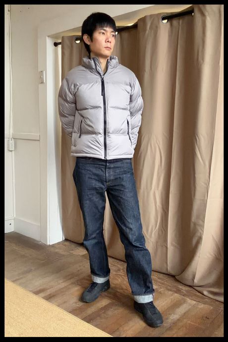 Photo of Strategist senior writer Michael Zhao wearing the Quince Men's Responsible Down Hoodless Puffer in gray