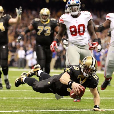 Drew Brees #9 of the New Orleans Saints dives into the endzone for a touchdown against the New York Giants at Mercedes-Benz Superdome on November 28, 2011.