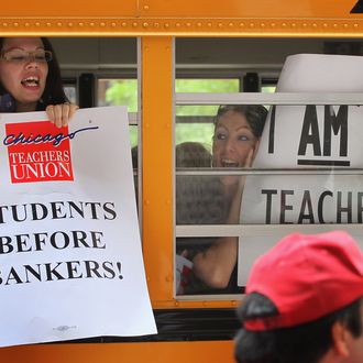 CHICAGO, IL - JUNE 22: Chicago school teachers display protest signs from inside a school bus as they leave a demonstration outside the Chicago Board of Education building on June 22, 2011 in Chicago, Illinois. Hundreds of teachers demonstrated outside the board's offices and marched through the city's financial district to protest the board's recent decision to rescind a 4 percent annual raise promised to the teachers in their contracts. (Photo by Scott Olson/Getty Images)