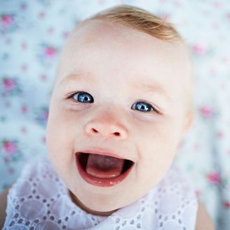 Portrait of smiling baby girl laying on mat