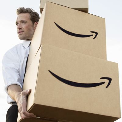 Businessman carrying stacked boxes on field