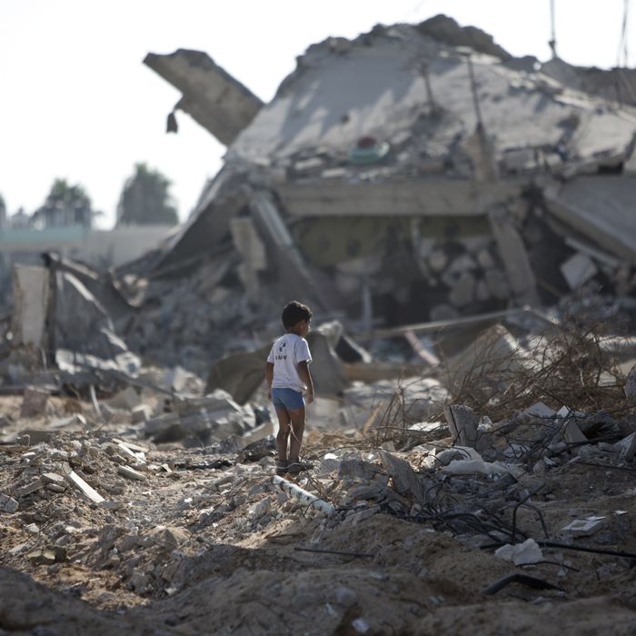 A Palestinian boy walks over debris as civilians who were displaced from their houses due to fighting between Israel's army and Hamas fighters return to check their homes in Gaza City's Shejaiya neighbourhood, on August 1, 2014. Israeli shelling killed eight people in Gaza today just hours into a three-day truce, medics said, as a diplomatic push for a more durable end to the bloodshed gained pace. It gave a brief respite to residents of the battered strip, after 25 days of violence that killed 1,459 on the Palestinian side, mostly civilians, and 61 soldiers and three civilians on the Israeli side. AFP PHOTO / MAHMUD HAMS (Photo credit should read MAHMUD HAMS/AFP/Getty Images)