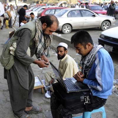 An Afghan street vendor sells music he uploads to customers' mobile phones in downtown Kabul.