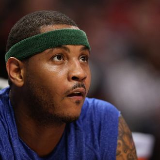 Carmelo Anthony #7 of the New York Knicks watches the action against the Chicago Bulls from the bench at the United Center on April 11, 2013 in Chicago, Illinois. The Bulls defeated the Knicks 118-111 in overtime. 