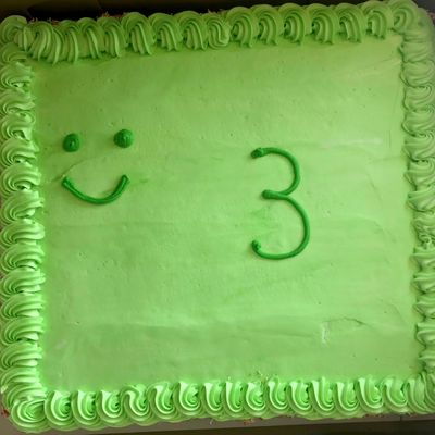 A cake with a smiley face and a number 3.