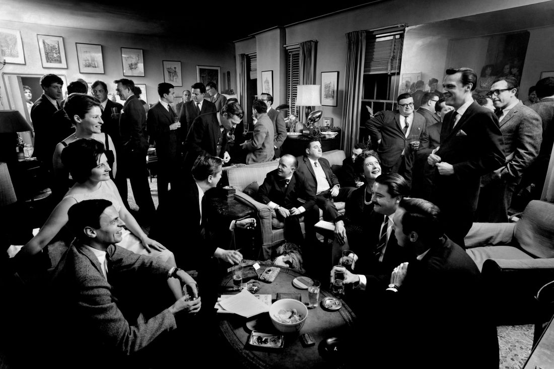 USA. New York City. 1963. Literary cocktail party at George PLIMPTON's Upper East Side apartment. Plimpton is seated at left with literary agent Maggie ABBOTT next to him. At top, left to right: Jonathan MILLER, Gore VIDAL, Ricky LEACOCK, Robert LASKEY, and Paul HELLER. In background, left to right: Ralph ELLISON and Peter MATTHIESEN. Center: Walter BERNSTEIN (seated on couch with back to camera); Sydney LUMET (behind Bernstein to right); Mario PUZO (leaning against mirror); Jack RICHARDSON (tall man, front, right foreground); Arthur KOPITT (foreground, right); Frank PERRY (left of Kopitt); Eleanor PERRY (left of Frank); Arthur PENN (obscured behind Eleanor) and Truman CAPOTE (center on couch).