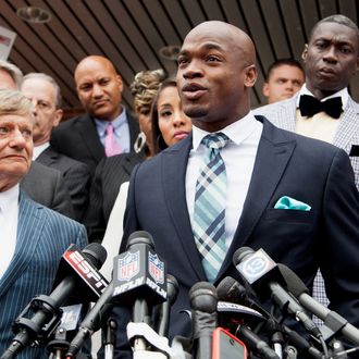 Defense attorney Rusty Hardin, (L) and NFL running back Adrian Peterson of the of the Minnesota Vikings address the media after Peterson plead 