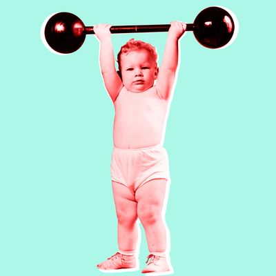 circa 1945: Studio portrait of an infant standing and holding a toy barbell over his head in a cloth diaper. (Photo by Lambert/Getty Images)