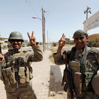 Iraqi soldiers gesture in center of Falluja