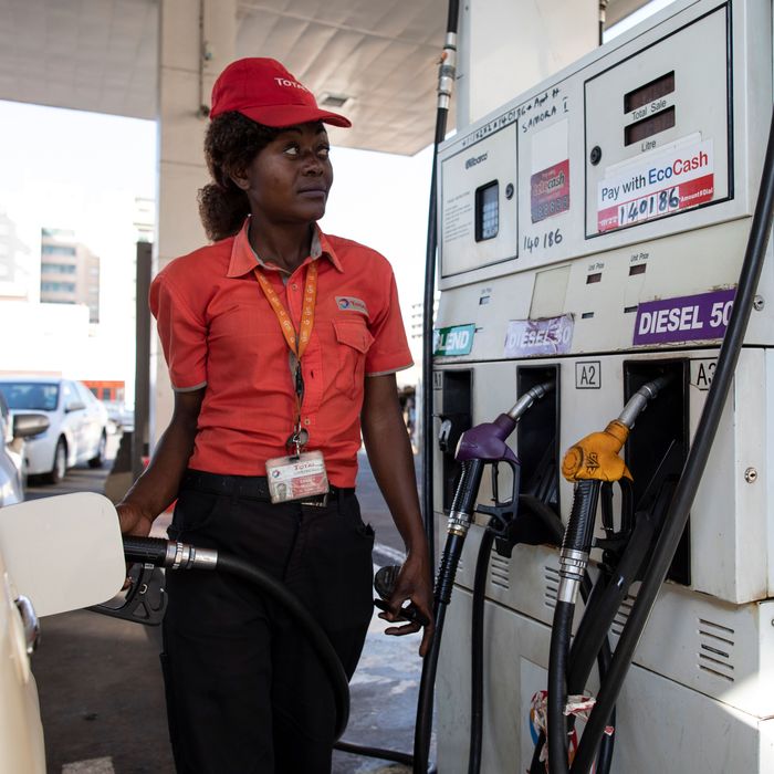 A gas station attendant fills a car in Harare, Zimbabwe. The country is in the midst of another major fuel shortage.