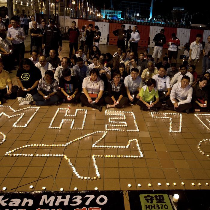 Malaysians take part in a candle-light vigil to mark one-month anniversary of the missing Malaysia Airlines MH370 flight at the Independence Square in Kuala Lumpur, early on April 8, 2014. An Australian navy ship has detected new underwater signals consistent with aircraft 'black boxes', the chief of the MH370 search said on April 7, calling it the 'most promising lead' yet in the month-old hunt for the missing plane. 