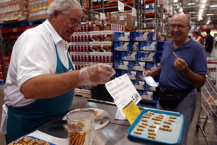 A man distributing cookie samples to a delighted customer at Costco 