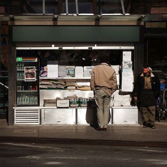 Jerry Delakas, 63, (R) a longtime newspaper vendor in Manhattan's Cooper Square, stands by his newsstand on April 3, 2012 in New York City. 