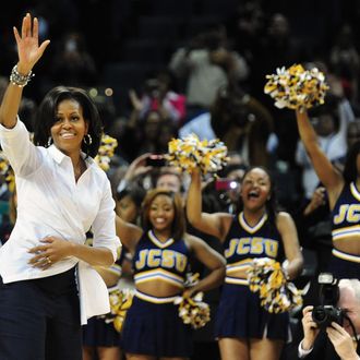 First lady Michelle Obama waves to the crowd as members of the Johnson C. Smith University cheerleaders cheer during the Let's Move! pre-game event during the CIAA Tournament at Time Warner Cable Arena on Friday, March 2, 2012 in Charlotte, North Carolina. 